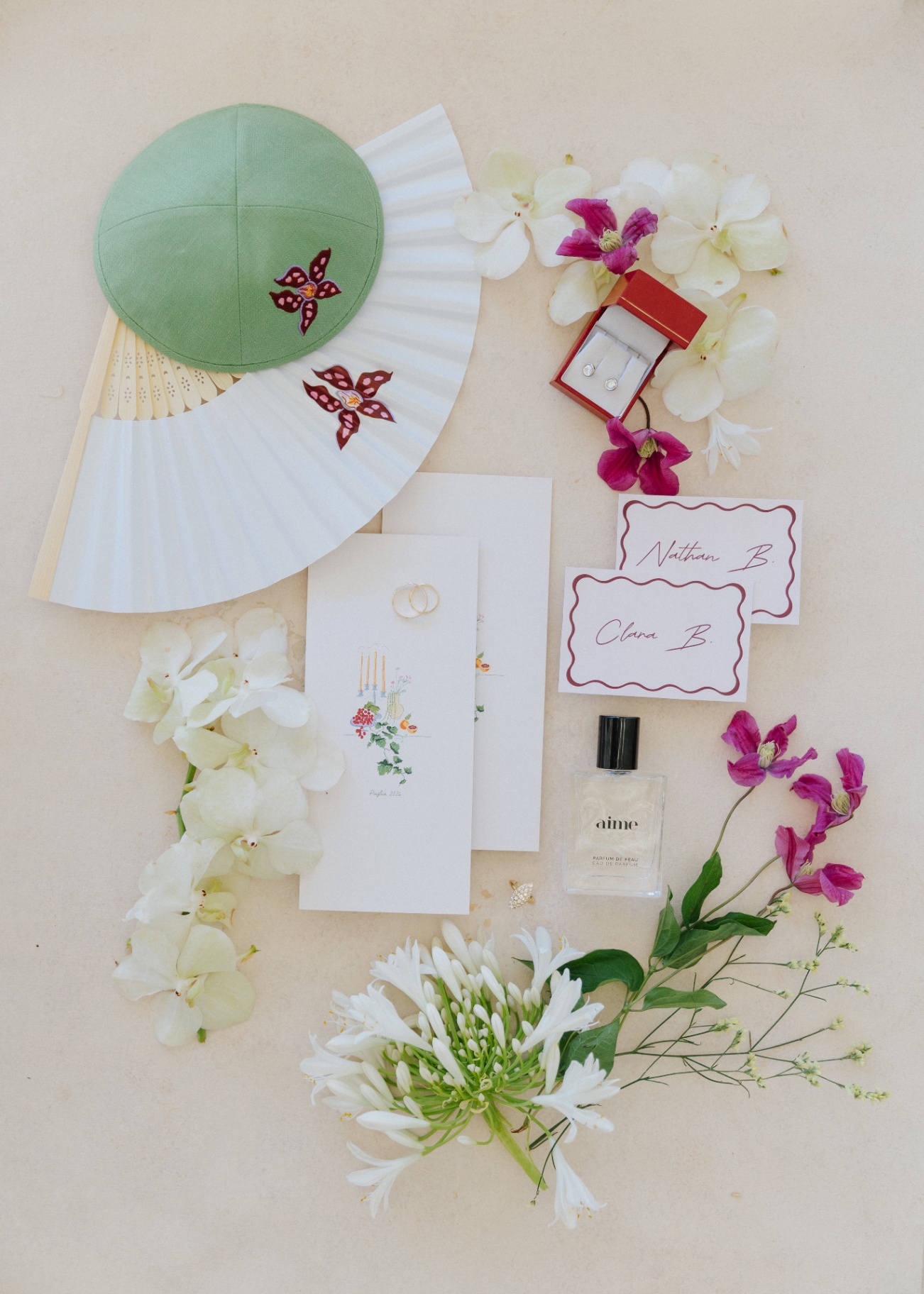 Vue en plongée d'accessoires cérémoniels : kippa, éventail, invitations et fleurs
