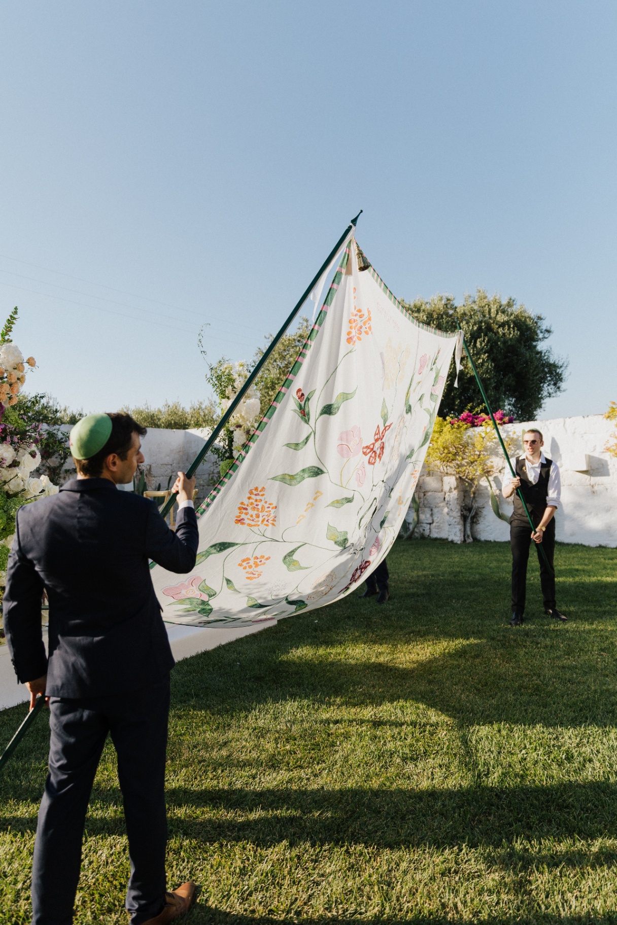 Voile de cérémonie tenu par deux porteurs en extérieur